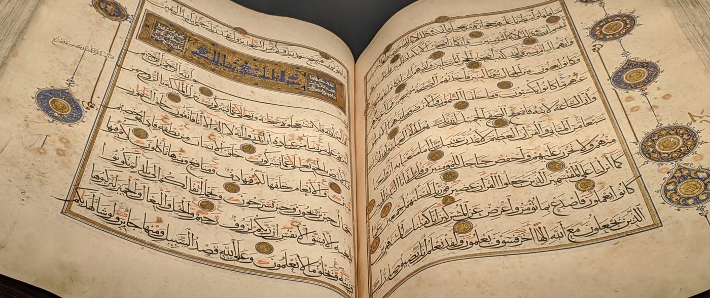 مصحف مفتوح على صفحتين مذهّبتين